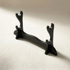 A black wooden desk stand for katana display with a unique reindeer antler-shaped design, shown on a beige textured surface for premium gaming setups.