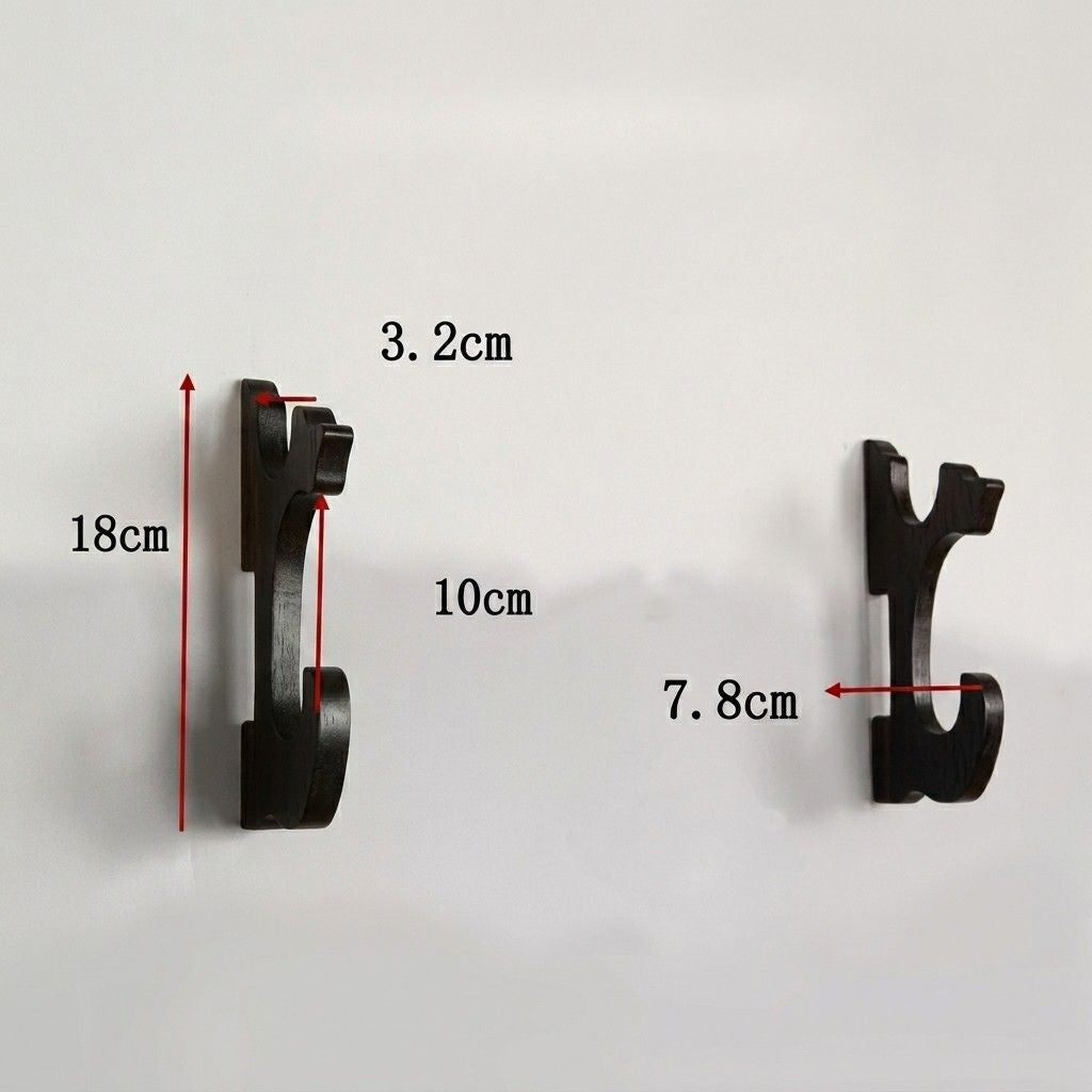 Detailed dimensions of black katana wall mounts, showing 18cm height and 7.8cm hook width for a perfect gaming room display from Dreams Setup.